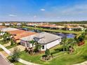 Scenic aerial shot of a home next to a lake, highlighting its well-manicured lawn and lush surroundings at 12448 Golden Sage Dr, Sarasota, FL 34238