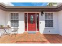 Close-up of the front door with glass window, brick patio, and charming details at 1302 5Th W St, Palmetto, FL 34221