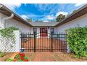 Inviting entrance with a brick patio, black metal gate, and lush landscaping at 1302 5Th W St, Palmetto, FL 34221