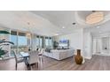 Bright living room featuring an open floor plan, floor-to-ceiling windows, and elegant light fixtures at 140 Riviera Dunes Way # 1203, Palmetto, FL 34221