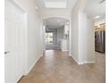 Spacious hallway featuring tile flooring, arched doorways, and seamless flow between living spaces at 14150 Cattle Egret Pl, Lakewood Ranch, FL 34202