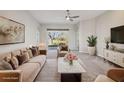 Bright living room with neutral tones, stylish furnishings, and sliding glass doors leading to outdoor view at 14150 Cattle Egret Pl, Lakewood Ranch, FL 34202