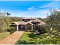 Beautifully landscaped front yard and brick driveway of a two-story home at 16748 4Th Ne Ave, Bradenton, FL 34212