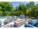Secluded backyard patio area with comfortable seating, a modern gas fire pit, and tropical landscaping at 2283 Arlington St, Sarasota, FL 34239