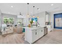 Open-concept kitchen featuring a large island, modern lighting fixtures, and seamless flow to living area at 2283 Arlington St, Sarasota, FL 34239