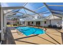 Enclosed in-ground pool with a screen enclosure and concrete deck, perfect for relaxation and entertainment at 3215 Pine Valley Dr, Sarasota, FL 34239