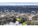 Scenic aerial view of the community with lush landscaping, a pond, and a cityscape in the distance at 3933 Glen Oaks Manor Dr, Sarasota, FL 34232
