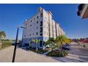 Condo building with parking lot, palm trees, and views at 501 Tamiami N Trl # 601, Venice, FL 34285