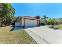Inviting home showcasing a well-manicured lawn, palm trees, and a convenient two-car garage at 5103 73Rd E St, Bradenton, FL 34203