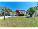 Lovely home with lush green lawn, landscaped with palm trees and brick-lined garden beds at 5103 73Rd E St, Bradenton, FL 34203