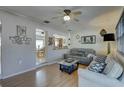 Comfortable living room with neutral tones, laminate flooring, ceiling fan, and stylish decor at 511 74Th N Ave, St Petersburg, FL 33702
