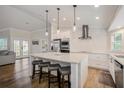 Bright, eat-in kitchen with white cabinets, stainless appliances, granite counters, and wood flooring at 5708 Holmes Blvd, Holmes Beach, FL 34217