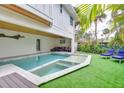 Relaxing backyard oasis with a sparkling pool, spa, and outdoor seating surrounded by lush greenery at 5708 Holmes Blvd, Holmes Beach, FL 34217