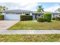 Attractive one-story home featuring a lush lawn and landscaping with an attached two car garage at 6722 Roxbury Dr, Sarasota, FL 34231