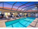 Relaxing screened-in pool area with lounge chairs, outdoor seating, and string lights at 6900 Country Lakes Cir, Sarasota, FL 34243