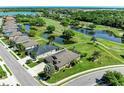 An aerial shot of a home on a large, well-maintained lawn bordering a pond and golf course at 9006 Raes Creek Pl, Palmetto, FL 34221