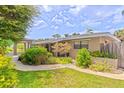 Charming single-story home featuring a manicured front yard with vibrant landscaping at 1011 68Th W Ave, Bradenton, FL 34207