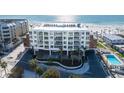 Stunning aerial view of the modern condominium building, parking, and beach at 1035 Seaside Dr # 603, Sarasota, FL 34242