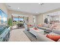 Bright and airy living room featuring neutral tones, modern furniture, and a sliding glass door leading to the outdoor patio at 11127 Devonbridge Dr, Palmetto, FL 34221