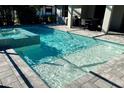 A rectangular pool features a baja shelf and a spa with mosaic tile surround at 12370 Marsh Pointe Rd, Sarasota, FL 34238