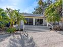 Home with a large sliding glass doors leading to a porch surrounded by tropical landscaping at 1374 Moonmist Dr # B1, Sarasota, FL 34242