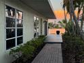 Charming home exterior featuring a brick walkway, lush greenery, and serene water views at 1374 Moonmist Dr # B1, Sarasota, FL 34242