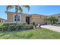 Well-maintained single-Gathering home with neatly trimmed hedges, palm tree and a two-car garage at 15008 Trinity Fall Way, Bradenton, FL 34212
