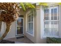 Charming front entrance featuring a glass paneled door and white framed window with shutter details at 1663 San Silvestro Dr, Venice, FL 34285