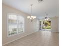An open-concept living area with tile flooring, arched windows and sliding glass doors at 1663 San Silvestro Dr, Venice, FL 34285