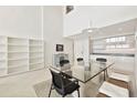 Bright dining area and glass table with eat-in kitchen area in background and modern shelving at 1990 Main St # 10, Sarasota, FL 34236