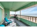 Charming covered balcony with comfortable seating and ocean views at 2350 N Beach Rd # 1B, Englewood, FL 34223