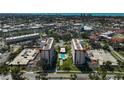 Aerial view of two condo buildings with a pool, surrounded by a city and the ocean in the background at 244 Saint Augustine Ave # 905, Venice, FL 34285