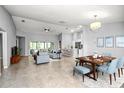Open-concept living area with tile flooring, modern furnishings, a ceiling fan, and ample natural light at 25259 Alcazar Dr, Punta Gorda, FL 33955