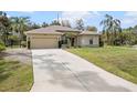 Well-maintained home with a large driveway and lush green lawn at 3189 Seattle Ave, North Port, FL 34286