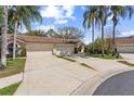 Charming home featuring a tile roof, attached two-car garage, and lush landscaping at 3815 Muirfield Ct, Palm Harbor, FL 34685