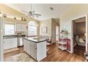 Eat-in kitchen featuring an island, white cabinets, and laminate floors at 3815 Muirfield Ct, Palm Harbor, FL 34685
