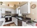 Bright kitchen with white cabinets, stainless steel dishwasher, and granite countertops at 3815 Muirfield Ct, Palm Harbor, FL 34685