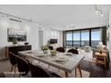Bright, staged living room with dining area, floor-to-ceiling windows, and waterfront views at 401 S Palm Ave # 801, Sarasota, FL 34236