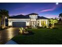 Charming single-Gathering home displaying manicured lawn and elegant front facade and garden, with brick driveway at 4735 Trento Pl, Bradenton, FL 34211