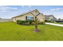 Well-maintained home exterior with green lawn, flowering plants and neutral color scheme at 4918 Gray Owl Ter, Palmetto, FL 34221