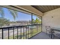 Balcony with seating overlooking a pool, building, and palm trees in a sunny, picturesque view at 503 Albee Farm Rd # B6, Venice, FL 34285
