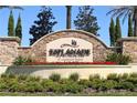 Entrance to Esplanade Golf and Country Club with a decorative stone sign and vibrant flower beds at 5031 Serata Dr, Bradenton, FL 34211