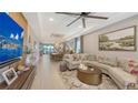 Spacious living room featuring a large sectional sofa, a modern ceiling fan, and an adjacent dining area at 5209 Barnett Cir, Lakewood Ranch, FL 34211