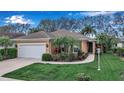 Charming single-story home featuring a well-manicured lawn and vibrant tropical landscaping at 5548 Simonton St, Bradenton, FL 34203
