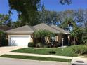 Charming single-story home featuring a well-manicured lawn and lush tropical landscaping in the front yard at 5548 Simonton St, Bradenton, FL 34203