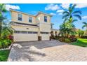 Elegant two-story home featuring a three-car garage and paver driveway at 5670 Rock Dove Dr, Sarasota, FL 34241