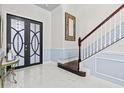 Bright foyer featuring marble floors, decorative staircase, and modern double doors at 5670 Rock Dove Dr, Sarasota, FL 34241