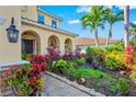 Lush landscaping surrounds the welcoming front entrance to this beautiful tan home at 5670 Rock Dove Dr, Sarasota, FL 34241