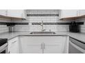 Close-up of kitchen with sleek countertops and tiled backsplash at 5855 Midnight Pass Rd # 327, Sarasota, FL 34242