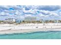 Beautiful white sand beach and ocean view with residential buildings in the background at 6140 Midnight Pass Rd # 103, Sarasota, FL 34242